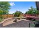Inviting backyard featuring a brick patio with a fire pit and a raised wooden deck, perfect for outdoor relaxation at 7226 S Eagles Nest Cir, Littleton, CO 80127