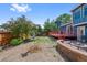 Spacious fenced backyard with a deck, patio area, mature trees, and well-maintained landscaping at 7226 S Eagles Nest Cir, Littleton, CO 80127