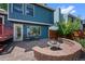 Backyard with brick fire pit, deck and seating area with mature trees at 7226 S Eagles Nest Cir, Littleton, CO 80127