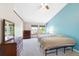 Bright bedroom with dual windows, light blue accent wall, ceiling fan, and wood dressers at 7226 S Eagles Nest Cir, Littleton, CO 80127
