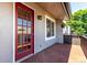 Red front door with glass panes and a brick porch at 2301 E Fremont Ave # W08, Centennial, CO 80122