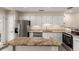 Granite countertops and stainless steel appliances shine in this kitchen with white cabinets at 2301 E Fremont Ave # W08, Centennial, CO 80122