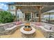 Inviting backyard patio with a cozy fire pit and comfortable built-in seating area under a wooden pergola at 5778 S Duquesne Ct, Aurora, CO 80016