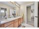 Bathroom featuring a double sink vanity with wood cabinets and door to an additional bathroom at 5778 S Duquesne Ct, Aurora, CO 80016