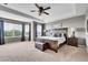 Spacious bedroom featuring tray ceiling, large windows, plush carpet, and a king bed at 5778 S Duquesne Ct, Aurora, CO 80016