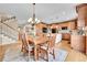 Dining area with hardwood floors and classic wooden table and chairs adjacent to stairs and kitchen at 5778 S Duquesne Ct, Aurora, CO 80016