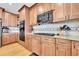 Kitchen with light wood cabinets, granite counters, backsplash, and black stainless appliances at 5778 S Duquesne Ct, Aurora, CO 80016