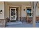 Cozy front porch with rocking chairs, decorative lights and a welcoming entrance at 4032 Donnington Cir, Castle Rock, CO 80104