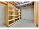 Unfinished basement storage area with shelving and concrete walls at 7796 S Marshall Ct, Littleton, CO 80128