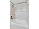 Bathroom featuring white tiled shower over tub and chrome shower head at 7796 S Marshall Ct, Littleton, CO 80128