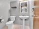 Simple, clean bathroom with pedestal sink, toilet, and framed mirror at 7796 S Marshall Ct, Littleton, CO 80128