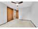 Bedroom featuring neutral carpet, ceiling fan, and doors leading to hallway and closet at 7796 S Marshall Ct, Littleton, CO 80128