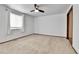 Minimalist bedroom with carpeted floors, a ceiling fan, and a large window at 7796 S Marshall Ct, Littleton, CO 80128