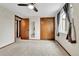 Bedroom with window, neutral carpet, closet, and door leading to hallway at 7796 S Marshall Ct, Littleton, CO 80128