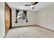 Bedroom with window view, neutral carpet, and ceiling fan for comfort at 7796 S Marshall Ct, Littleton, CO 80128