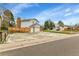 View of house showing a basketball hoop, a wooden fence, attached garage and concrete driveway at 7796 S Marshall Ct, Littleton, CO 80128