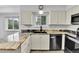 Bright kitchen with granite counters, stainless appliances, and a window over the sink at 7796 S Marshall Ct, Littleton, CO 80128