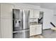 Modern kitchen with stainless steel refrigerator, granite countertop, and white cabinetry at 7796 S Marshall Ct, Littleton, CO 80128