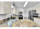 Modern kitchen with stainless steel appliances, granite counters, and ample cabinet space at 7796 S Marshall Ct, Littleton, CO 80128