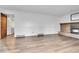 Large living room featuring hardwood floors, paneled walls, and a cozy brick fireplace at 7796 S Marshall Ct, Littleton, CO 80128
