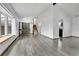Spacious living area with wood-look floors, large windows, and a staircase at 7796 S Marshall Ct, Littleton, CO 80128