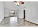 Open living room with wood-look floors, a ceiling fan, a bay window and a glimpse of the kitchen at 7796 S Marshall Ct, Littleton, CO 80128
