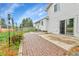 Back patio featuring a brick path leading to a sliding glass door and lush green lawn at 7796 S Marshall Ct, Littleton, CO 80128