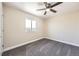 Bright bedroom with a ceiling fan, gray carpet, and a window with a view of the outdoors at 1805 August Ln, Brighton, CO 80601