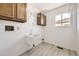 Functional laundry room with wood cabinets, utility sink, and natural light at 1805 August Ln, Brighton, CO 80601