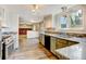 Open kitchen leading to a living room with a brick fireplace and new flooring at 1487 S Zeno Way, Aurora, CO 80017
