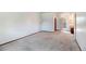 Bright living room features neutral carpet and white walls, with an open door to the outside at 1487 S Zeno Way, Aurora, CO 80017