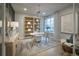 Bright home office featuring a modern desk, ample shelving, and a comfortable seating area at 4145 N Duquesne Ct, Aurora, CO 80019