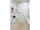 Walk-in shower features stylish marble tiling, built-in shelves, and pebble floor at 3825 S Monaco Pkwy # 111, Denver, CO 80237