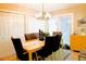 Bright dining area features a modern chandelier, ample natural light, and seating for four at 3825 S Monaco Pkwy # 111, Denver, CO 80237