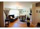 Inviting living room with wood floors, plenty of seating, and natural light from a large window at 3825 S Monaco Pkwy # 111, Denver, CO 80237