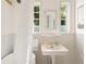 Bright bathroom features a pedestal sink, vintage fixtures, and natural light from large windows at 4508 W 34Th Ave, Denver, CO 80212