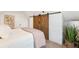 Bright bedroom featuring wood floors, large sliding barn doors, and a comfortable bed at 4508 W 34Th Ave, Denver, CO 80212