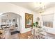 Open dining room with hardwood floors, glass table, and views into the living room at 4508 W 34Th Ave, Denver, CO 80212