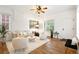 Well-lit living room with hardwood floors, ceiling fan, large windows, comfortable seating, and stylish decor at 4508 W 34Th Ave, Denver, CO 80212