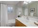 Bright bathroom with a tub/shower combo, oak vanity with ample counter space, and large mirror at 14650 Tejon St, Broomfield, CO 80023