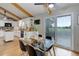 Bright dining area with a sliding glass door, wooden floors, exposed beams, and a glass table at 14650 Tejon St, Broomfield, CO 80023