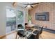 Dining room with exposed wooden beams, brick wall, fireplace, sliding glass door, and glass table at 14650 Tejon St, Broomfield, CO 80023