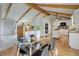 Open kitchen and dining area featuring modern decor, exposed beams, white cabinets and a glass table at 14650 Tejon St, Broomfield, CO 80023