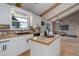 Bright kitchen features white cabinetry, wooden countertops, an island, and exposed wooden ceiling beams at 14650 Tejon St, Broomfield, CO 80023