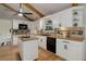 Well-lit kitchen features white cabinetry, butcher-block counters, black appliances and an island with additional storage at 14650 Tejon St, Broomfield, CO 80023
