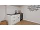 Basement wet bar with white shaker cabinets and black countertop at 7 Red Maple, Littleton, CO 80127