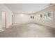 Open unfinished basement space featuring concrete flooring, and a door to a potential storage space at 4800 E Cedar Ave, Denver, CO 80246