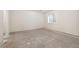 Bright unfinished basement with concrete floors, modern windows, and a door to a side room at 4800 E Cedar Ave, Denver, CO 80246