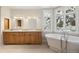 Bathroom with dual sinks, soaking tub, and natural light from the windows at 4800 E Cedar Ave, Denver, CO 80246