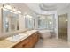 Bathroom with dual sinks, soaking tub, and natural light from the windows at 4800 E Cedar Ave, Denver, CO 80246